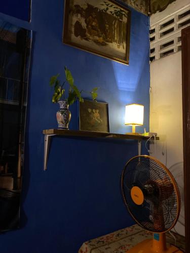a blue room with a fan and a blue wall at HostelBed and Art Space Phichai in Phichai