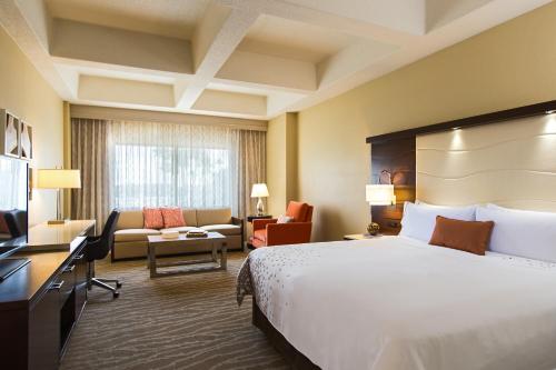 a hotel room with a bed and a living room at Renaissance Orlando at SeaWorld® in Orlando