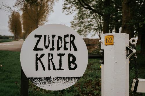 a sign that says under k rite next to a yard at Bed en Brood in de Kapschuur - Boerderij de ZuiderKRIB in Kraggenburg