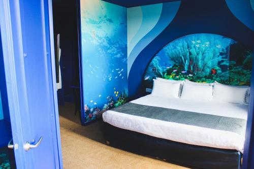 a bedroom with an aquarium themed room with a bed at Explorers Hotel Marne-la-Vallée in Magny-le-Hongre