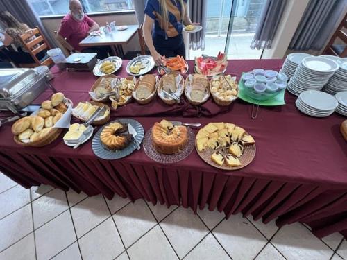 a table with a purple table cloth with food on it at Hotel Central in Porto Velho