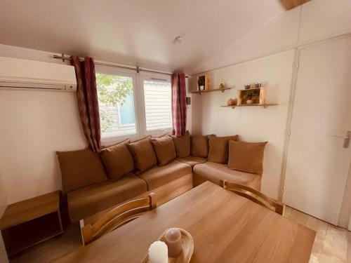 un salon avec un canapé et une table dans l'établissement Mobil Home Bouginvilliers 4, à Valras-Plage