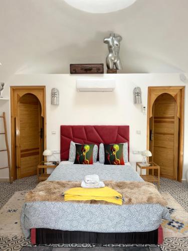 a bedroom with a large bed with a red headboard at Villa Roswell Marrakech in Marrakech