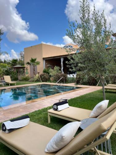 a resort with a swimming pool and two lounge chairs at Villa Roswell Marrakech in Marrakech