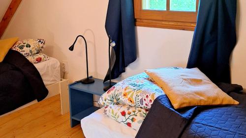 a bedroom with a bed and a lamp next to a window at Wild Grape - Vadszőlő in Badacsonytomaj