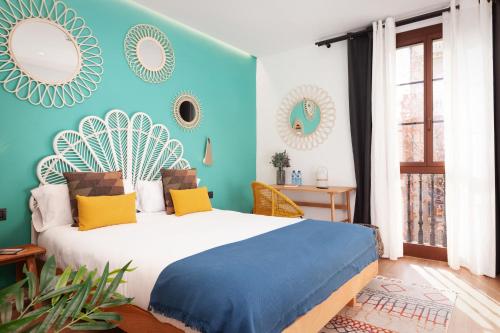 a bedroom with a bed with blue walls and mirrors at Casa Vaganto in Barcelona