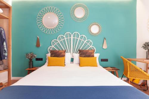 a bedroom with a bed with blue walls and mirrors at Casa Vaganto in Barcelona