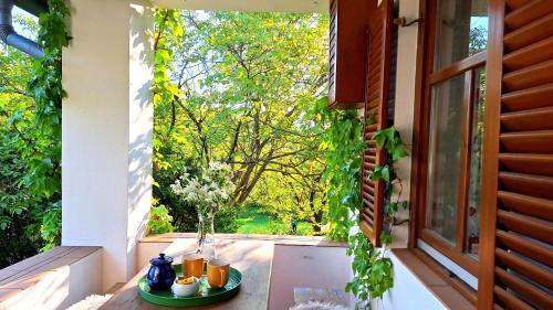 a balcony with a table with cups and a window at Wild Grape - Vadszőlő in Badacsonytomaj