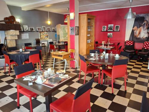 un restaurant avec des tables, des chaises et des murs rouges dans l'établissement Le petit poucet, à Saint Lo