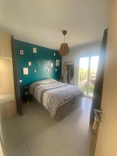 - une chambre dotée d'un lit avec un mur vert dans l'établissement Appartement toit terrasse, piscine, plages à 10min et parking, à Fréjus