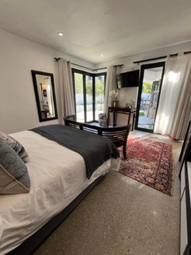 a bedroom with a large bed and a living room at Helder Haven Cottage in Somerset West