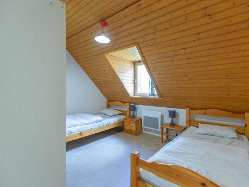 una camera mansardata con due letti e una finestra di Chalet 3 chambres avec terrasse à Cauterets pour 6 personnes - FR-1-401-21 a Cauterets