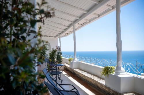 a balcony with chairs and the ocean in the background at Villa Santa Chiara Positano Suites in Positano