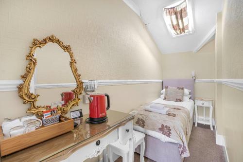 a dressing room with a mirror and a bed at Summerlands Guest House in Torquay