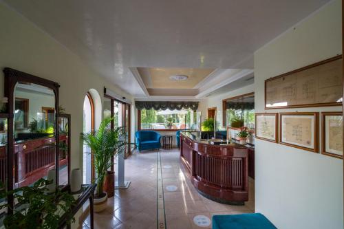 a lobby of a restaurant with a bar and plants at Park Hotel Villa Maria in San Menaio