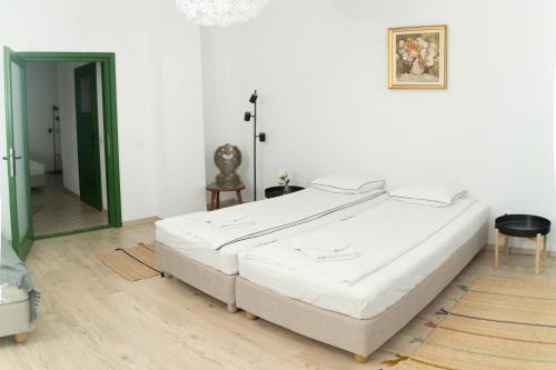 a bedroom with a large white bed and a mirror at Casa Botár Vendégház in Rimetea