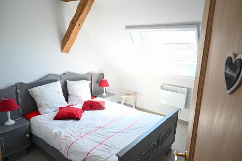 a bedroom with a bed with red pillows and a window at Le Maffe de Scourmont in Chimay