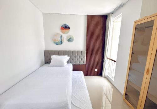 a small room with a bed and a mirror at Idyllic 3BR House in Northwest Park West Surabaya by Le Ciel Hospitality in Djrawat