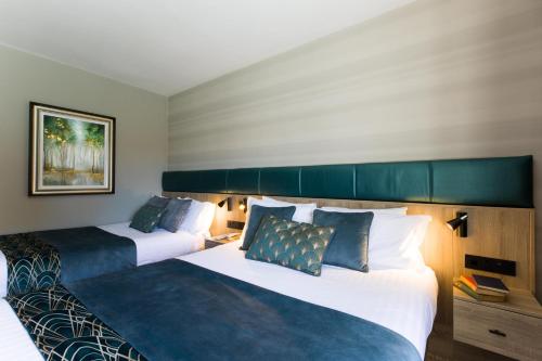 two beds in a hotel room with two at Scott's Hotel in Killarney