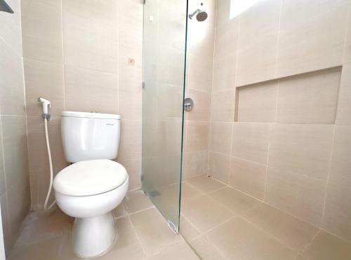 a bathroom with a toilet and a glass shower at Idyllic 3BR House in Northwest Park West Surabaya by Le Ciel Hospitality in Djrawat