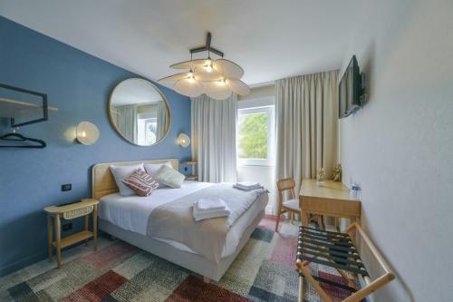 a bedroom with a bed and a desk and a mirror at BHOMA Bourges - Hôtel in Bourges