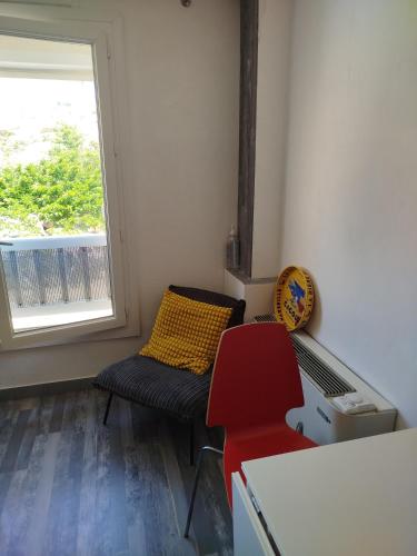 Cette petite chambre comprend une chaise et une fenêtre. dans l'établissement Île du Frioul, à Marseille