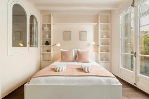 - une chambre blanche avec un grand lit et des étagères blanches dans l'établissement Cosy studio with terrace near Notre-Dame, à Paris
