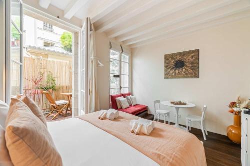 une chambre avec un lit, une table et des chaises dans l'établissement Cosy studio with terrace near Notre-Dame, à Paris