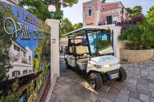 a golf cart parked next to a building at Park Hotel Villa Maria in San Menaio