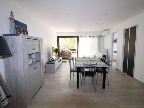 une cuisine et une salle à manger avec une table et des chaises dans l'établissement 3 pièces climatisé avec terrasse, parking privé, à 100m de la plage, 7 couchages - FR-1-307-148, au Grau-du-Roi
