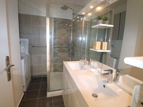 une salle de bain avec un lavabo et une douche avec un miroir dans l'établissement 3 pièces climatisé avec terrasse, parking privé, à 100m de la plage, 7 couchages - FR-1-307-148, au Grau-du-Roi