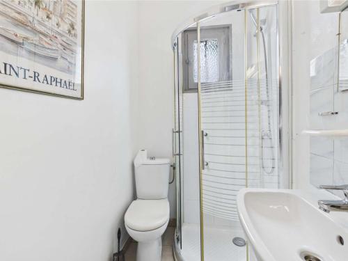 une salle de bain blanche avec des toilettes et un lavabo dans l'établissement Appartement RDC 5 pers avec grande terrasse sud, proche marché, animaux admis - Marseillan Plage - FR-1-326-712, à Marseillan