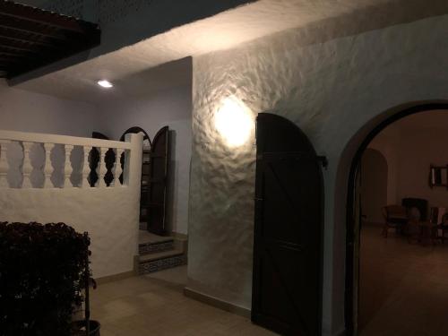 a hallway with a black door and a room with chairs at Villa Thalassa in Oulad Akkou