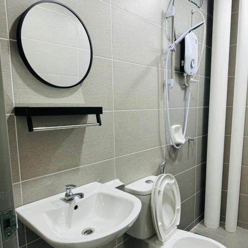 a bathroom with a sink and a mirror and a toilet at Sky9Haven Homestay in Ipoh