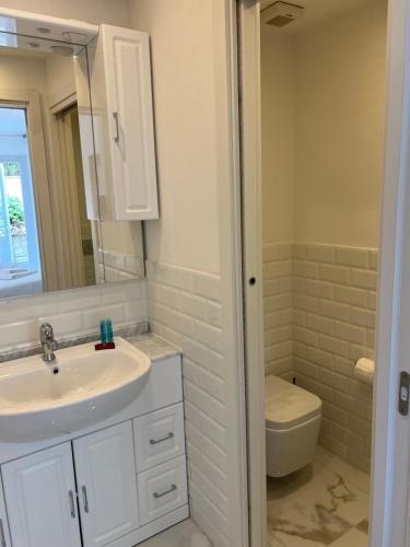 a white bathroom with a sink and a toilet at Maison d' Orange - Chambres in Saint-Tropez