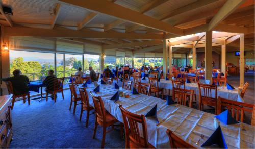 un restaurante con mesas y sillas con gente sentada a su lado en Port Arthur Motor Inn, en Port Arthur