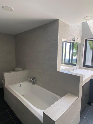 a white bath tub in a bathroom with a window at Guincho Rural Villa in Cascais