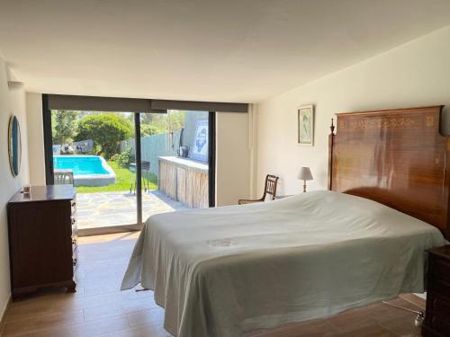a bedroom with a bed and a view of a pool at Guincho Rural Villa in Cascais