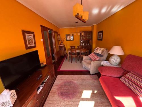 a living room with a couch and a flat screen tv at La terraza de Los Picos de Europa in Potes