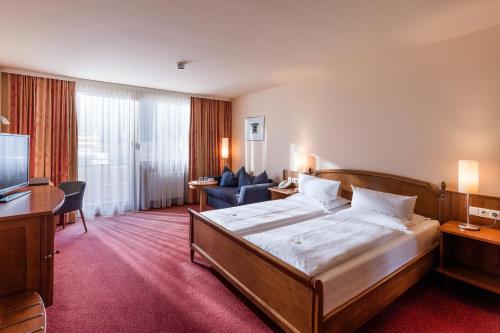 a hotel room with a bed and a living room at Vivea Hotel Bad Bleiberg in Bad Bleiberg