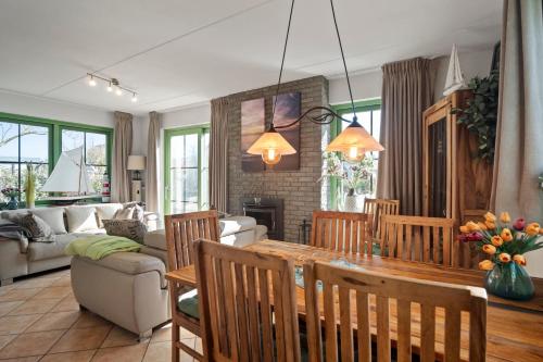 a living room with a wooden table and chairs at Vakantiehuis Sina in Julianadorp