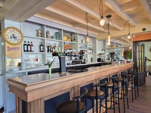 un bar dans un restaurant avec des tabourets dans l'établissement Gîte Bîn Vendüd Châ Nous, à Le Monastier sur Gazeille