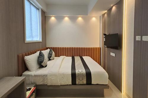 a bedroom with a bed and a window and a television at FabHotel Melody Boutique - Village Vadavali, Thane in Thane