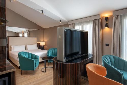 a hotel room with a bed and a flat screen tv at Hotel St Martin by OMNIA hotels in Rome