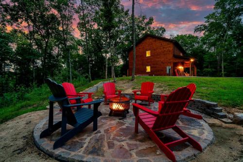 eine Gruppe von Stühlen, die um eine Feuerstelle herum sitzen in der Unterkunft Serene Cabin with Hot-tub and Fire Pit in Pigeon Forge, Tennessee in East Fork