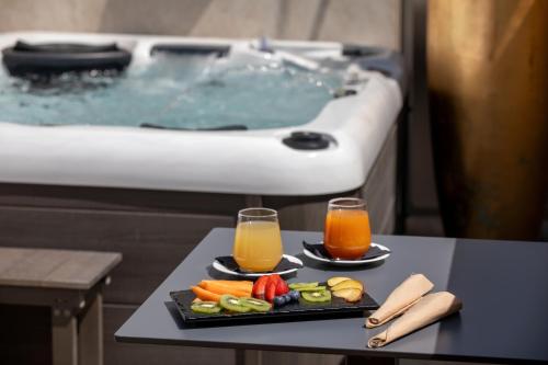 a tray of fruit and juice on a table next to a tub at Hotel St Martin by OMNIA hotels in Rome