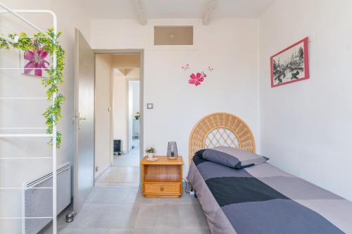 a small bedroom with a bed and a table at Coeur de Lavande in Vinon-sur-Verdon