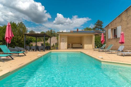 une grande piscine avec chaises et parasols dans l'établissement Coeur de Lavande, à Vinon-sur-Verdon