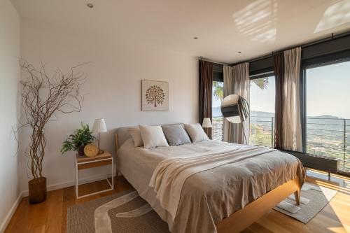 a bedroom with a large bed and a large window at 4 BR vila 25 minutes to Barcelona Fantastic sea views pool in Alella