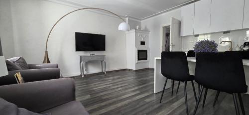 a living room with a couch and a table with chairs at Perfect Stay - "Campari Glam Apartments" in Toruń
